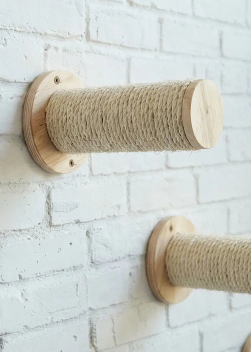 Close-up of the Purrfait Climber wall-mounted cat steps, featuring durable sisal-wrapped cylindrical posts securely mounted on a white brick wall for vertical climbing.