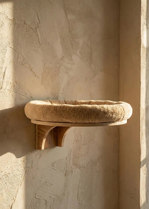 The Purrfait Orbit, a floating cat wall shelf featuring a sturdy wooden bracket and a thick, ultra-soft beige plush cushion designed to blend into modern home interiors.